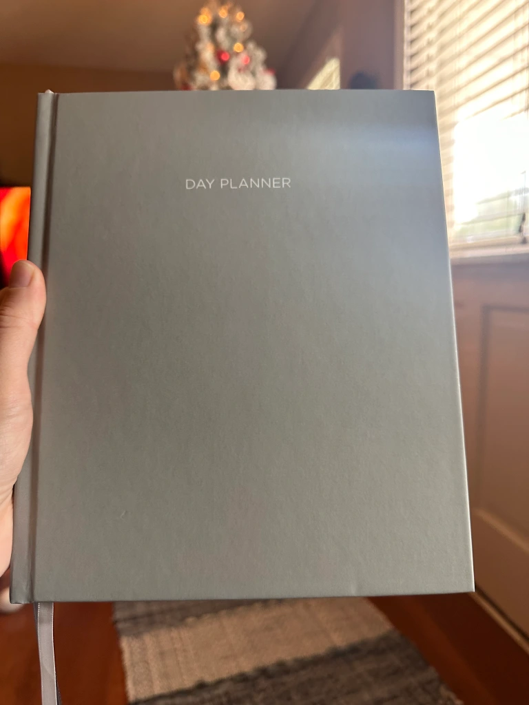 gray planner in front of a glittering Christmas tree