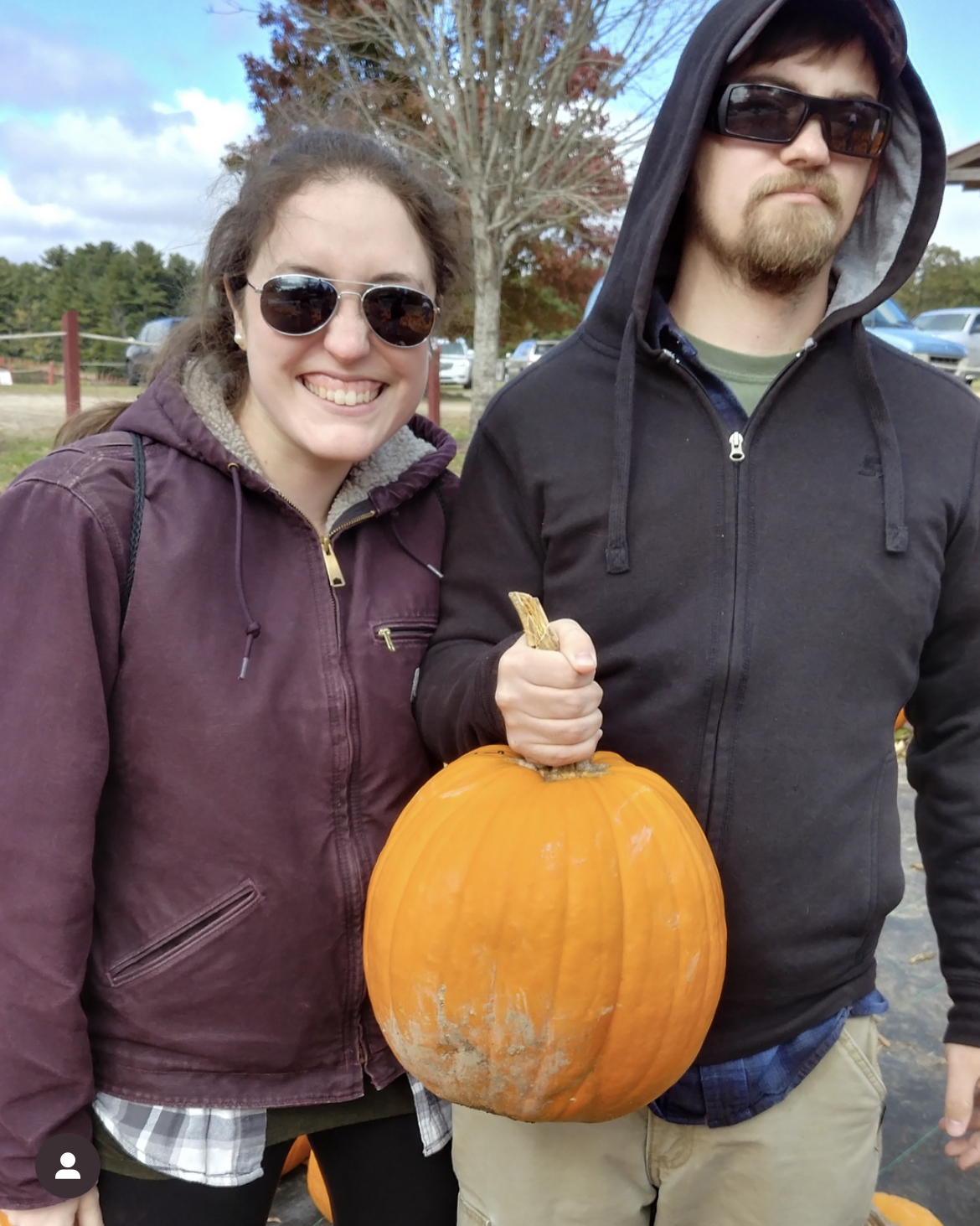 my husband and I holding a pumpkin we picked